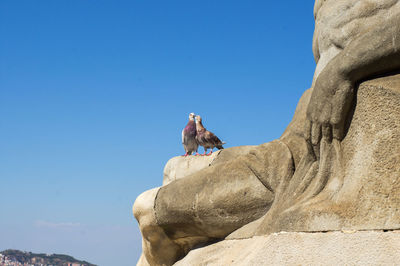 Low angle view of rock formation against clear blue sky