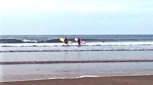 People on beach against sky