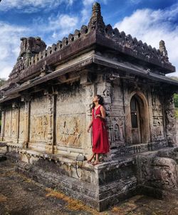 Rear view of woman standing outside historic building