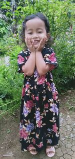 Portrait of smiling girl standing against plants