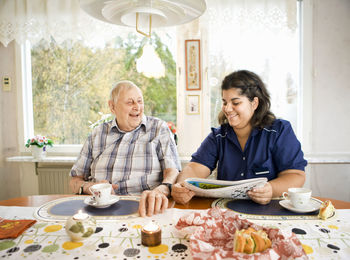 Nurse with senior man at table, sweden