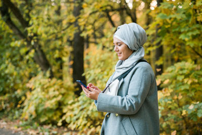 Side view of young woman using mobile phone