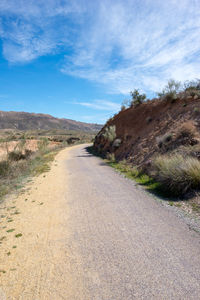 Road amidst land against sky