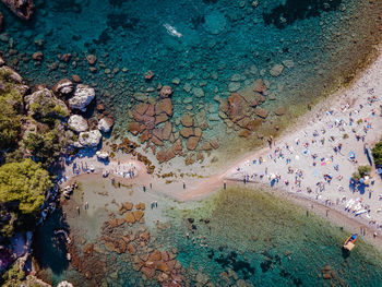 High angle view of crowd on rock by sea