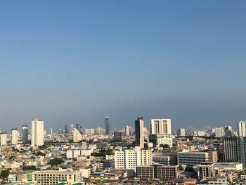 Buildings in city against clear sky