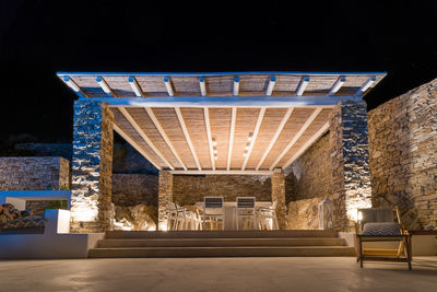 Trendy outdoor patio pergola shade structure, and patio roof, garden lounge and chairs. night shot