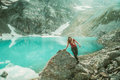 Young woman standing on rock against mountains