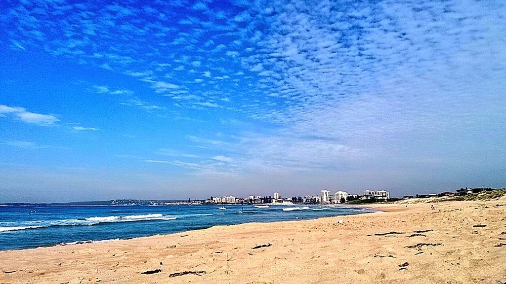 beach, sea, water, sky, shore, sand, blue, building exterior, built structure, architecture, cloud - sky, scenics, tranquility, tranquil scene, coastline, beauty in nature, nature, city, cloud, horizon over water