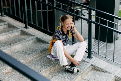 Young woman sitting on staircase