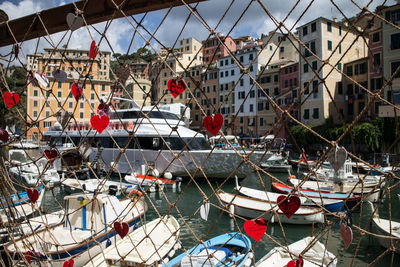 Close-up of heart shape decorations hanging on rope in city against sky