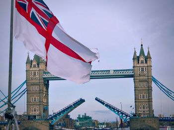 Union jack waving against tower bridge in city