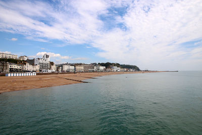 Scenic view of sea by buildings against sky