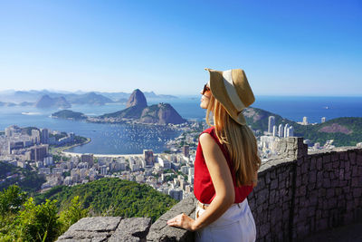 Woman on terrace in rio de janeiro with guanabara bay and the cityscape of rio de janerio, brazil