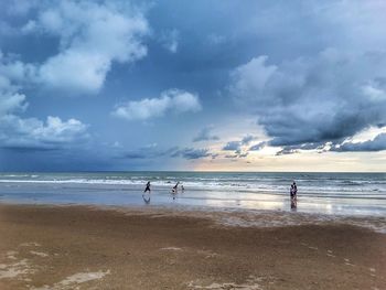 People on beach against sky