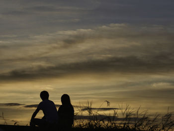 Silhouette couple against sky during sunset