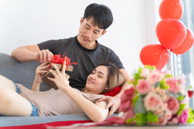 Woman holding red flower in living room