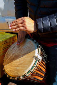 Midsection of man playing drum