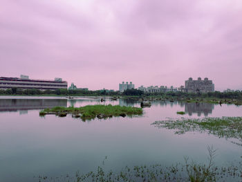 Reflection of buildings in lake against sky