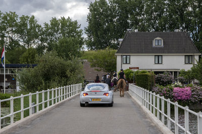 Cars on street by buildings against sky