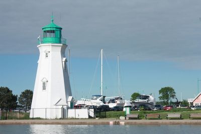 Lighthouse by sea against sky