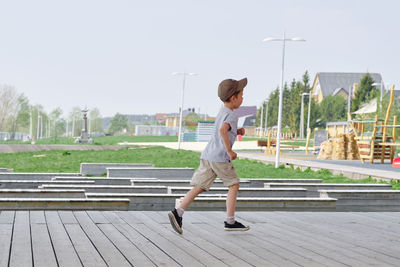 Boy runs on the veranda in the street. happy and active childhood of the child