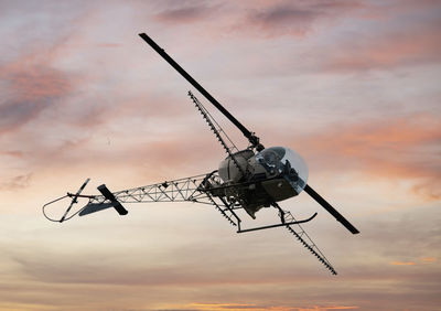 Low angle view of airplane flying against sky during sunset