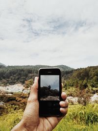 Cropped hand holding mobile phone