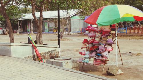 Woman holding umbrella against building during rainy season