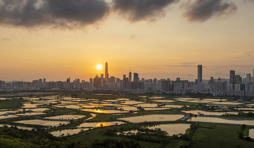 Aerial view of buildings in city during sunset