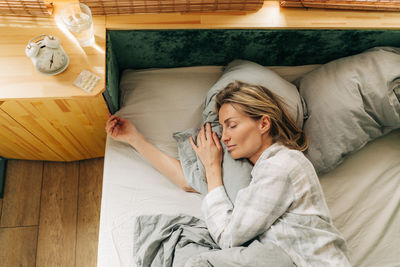 Portrait of young woman sleeping on bed at home