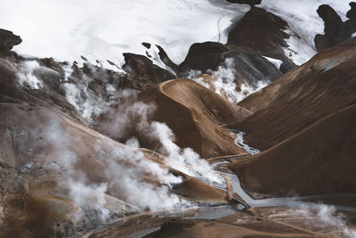 High angle view of steam emitting from volcanic mountains