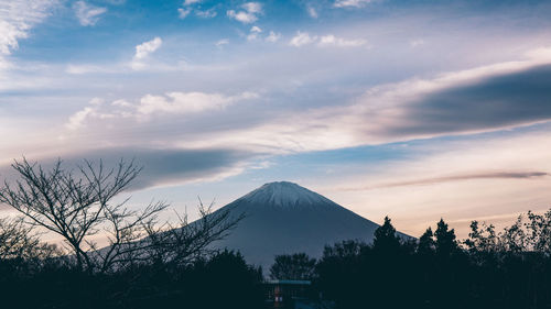 Scenic view of mountain against cloudy sky during sunset