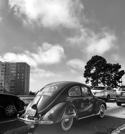 Cars on road against sky in city