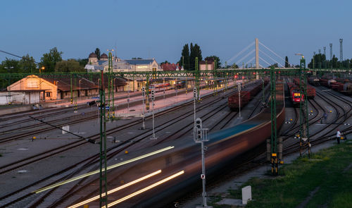 Trains on tracks against sky during sunset