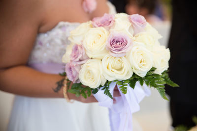 Midsection of bride holding bouquet during wedding
