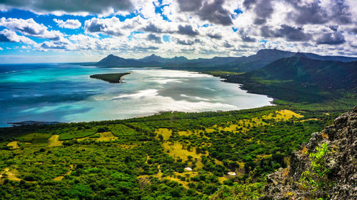 Scenic view of sea and mountains against sky