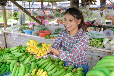 Young woman with fruits at market stall