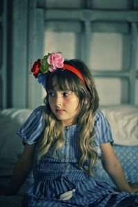 Portrait of young woman sitting on bed at home