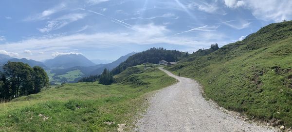 Road leading towards mountains against sky