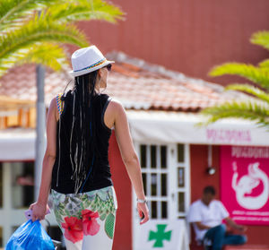 Rear view of woman standing against built structure