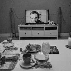 Man with vegetables on table against wall at home