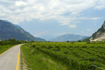 Road leading towards mountains against sky