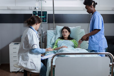 Nurse and doctor examining patient in hospital