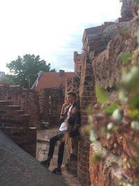 Full length of man climbing on wall of building