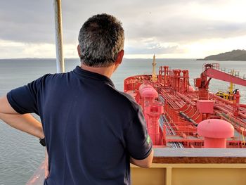 Rear view of man standing against sea