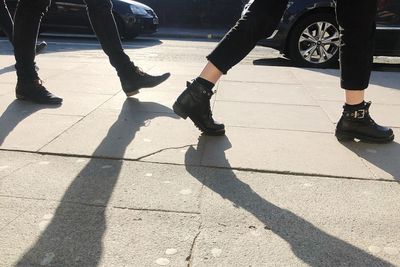 Low section of people walking on street in city