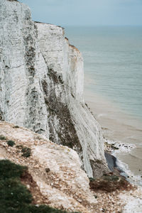 Rock formation on beach against sky