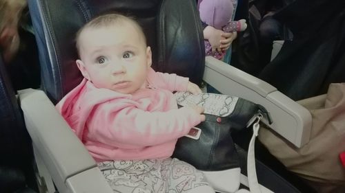 Portrait of cute baby girl sitting in bus