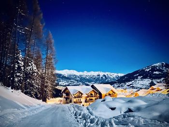 Scenic view of snow covered mountains against blue sky