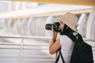 Tourist photographing while standing on bridge